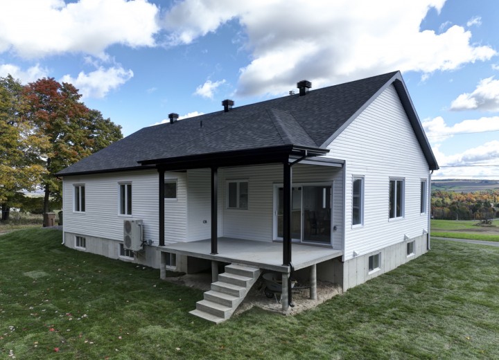 Vue-arriere-patio-beton-couvert-Maison-modele-2024-Constructions-Andre-Jacques-Warwick